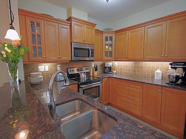The Conservatory spacious kitchen with stainless steel appliances in Kelowna, BC