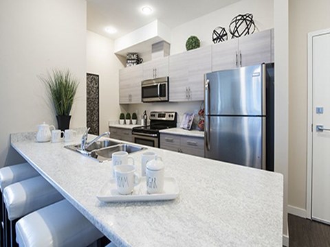 a kitchen with a counter top and a stainless steel refrigerator