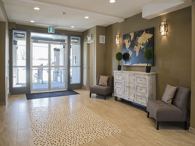 a lobby with two chairs and a chest of drawers