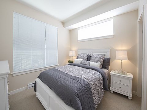 a bedroom with a bed and two windows