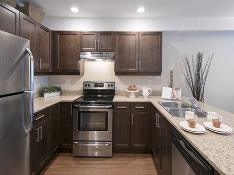 a kitchen with stainless steel appliances and brown cabinets