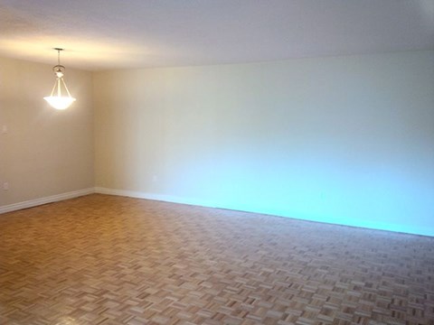 an empty living room with a light on the wall
