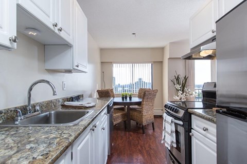 a kitchen with a sink and a stove and a dining room
