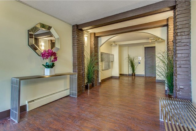 Citadel in North Vancouver, BC Apartment hallway with hardwood floors and brick archways