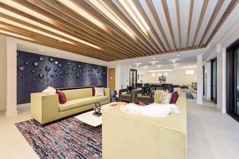A living room with a yellow couch and a patterned rug.