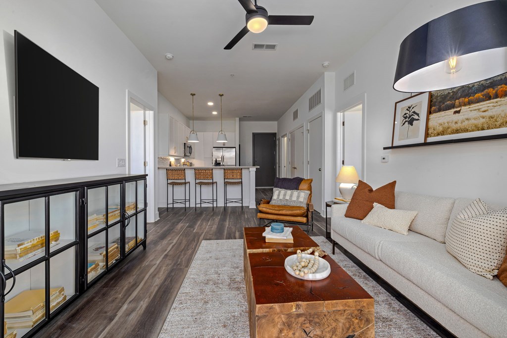 A modern living room with a large TV, a sofa, and a coffee table.