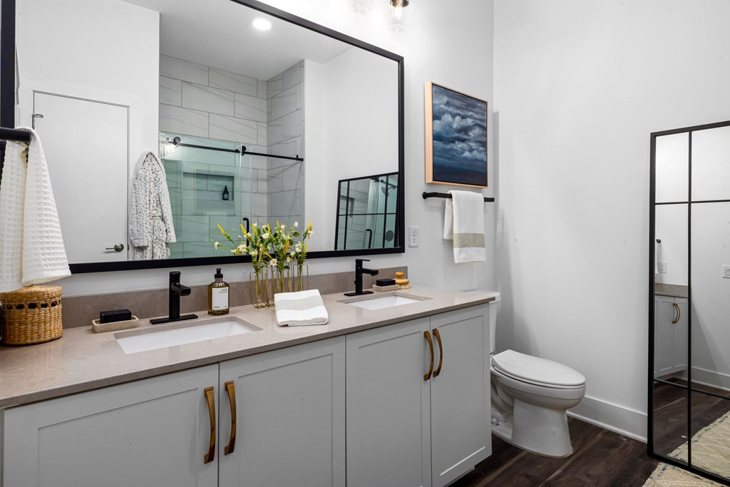 A bathroom with a white toilet and a large mirror.