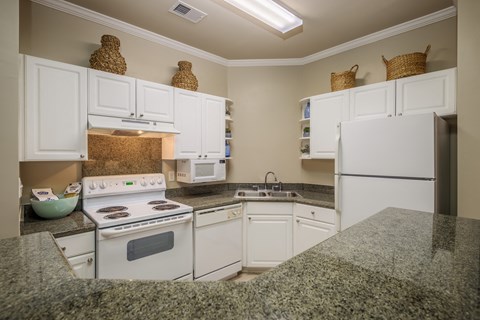a kitchen with white appliances and granite counter tops