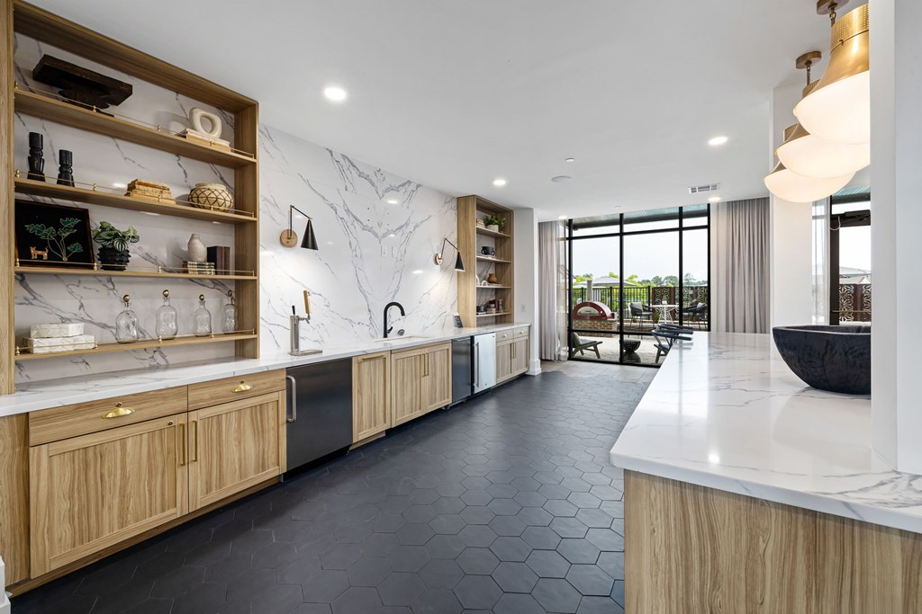 A modern kitchen with wooden cabinets and a marble countertop.