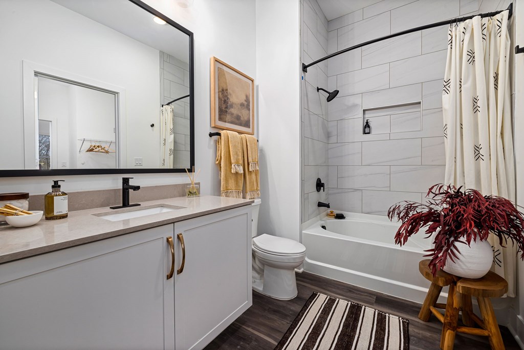 A bathroom with a white toilet, sink, and bathtub.