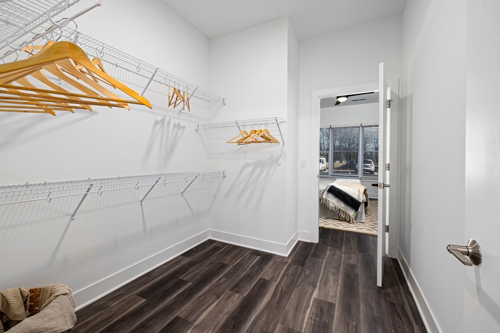 A room with a white wall and a row of yellow hangers.