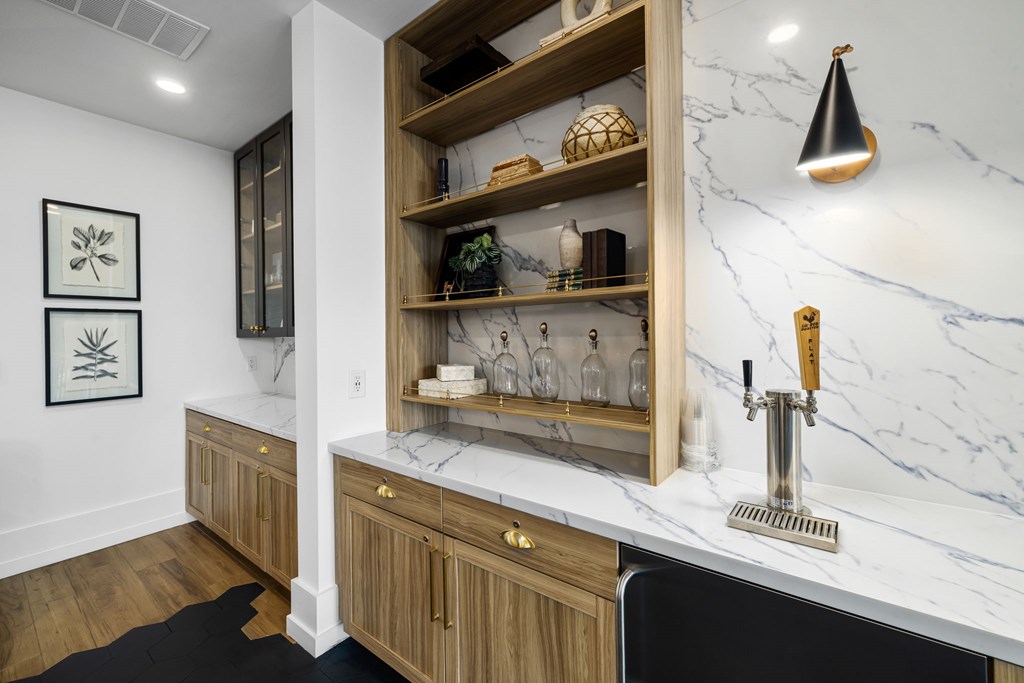 A kitchen with a marble counter top and wooden cabinets.