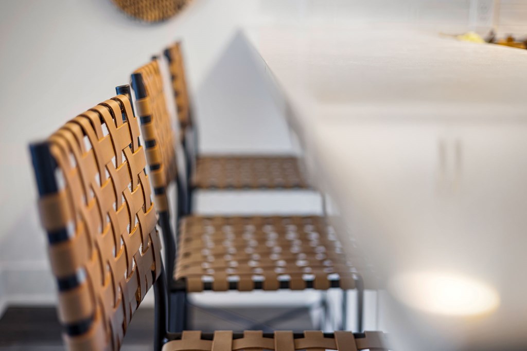 A row of brown wicker chairs are lined up in a row.