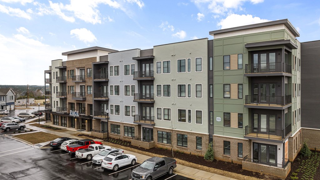 Apartment building with cars parked in front.