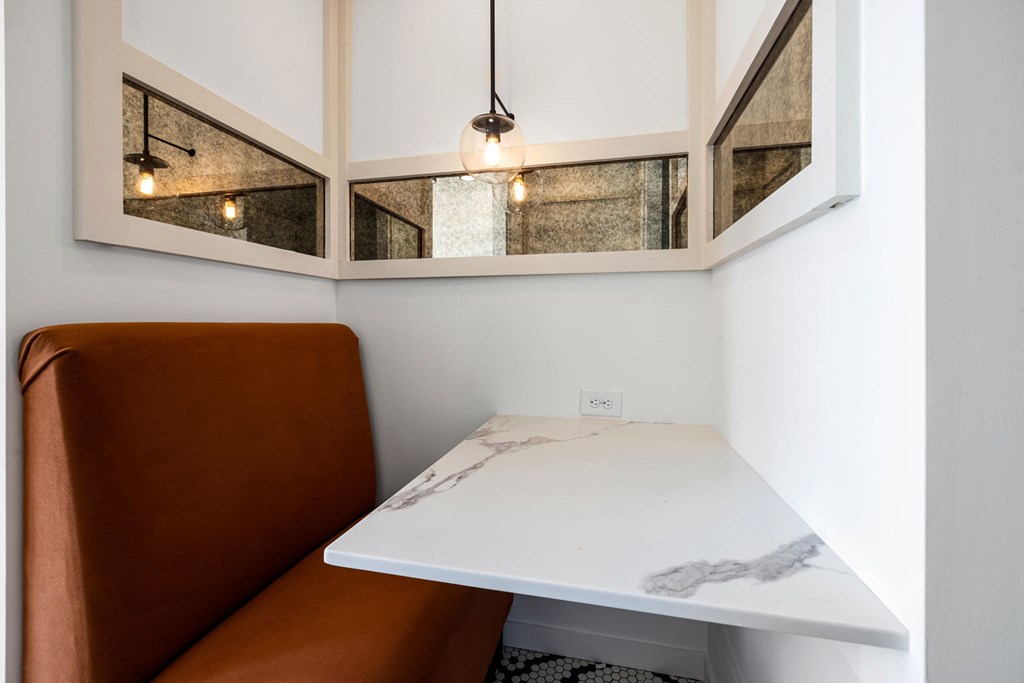 A brown leather sofa sits under a white table with a marble top.