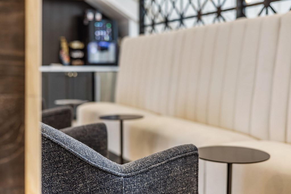 A white couch with a grey chair in front of it.