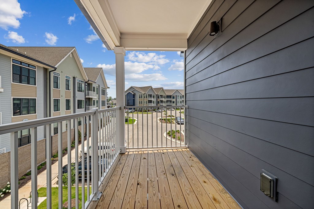 A balcony with a railing and a view of a residential area.