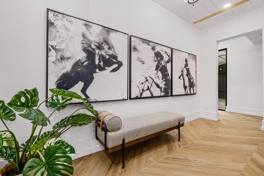 A room with a bench and three pictures on the wall.