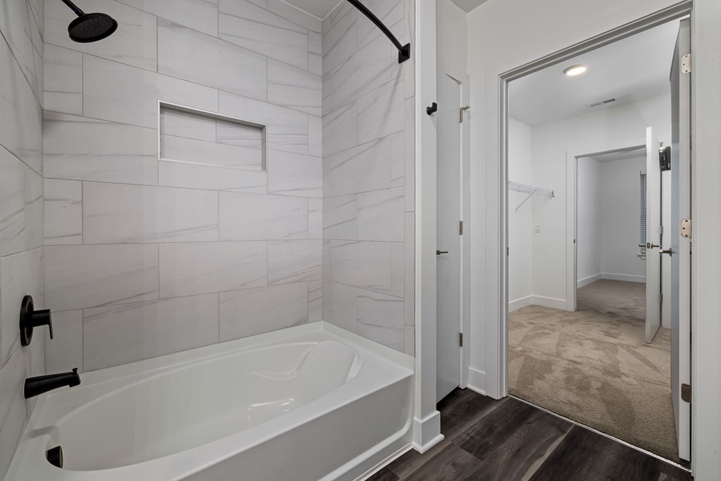 A white bathroom with a tub and a walk in shower.