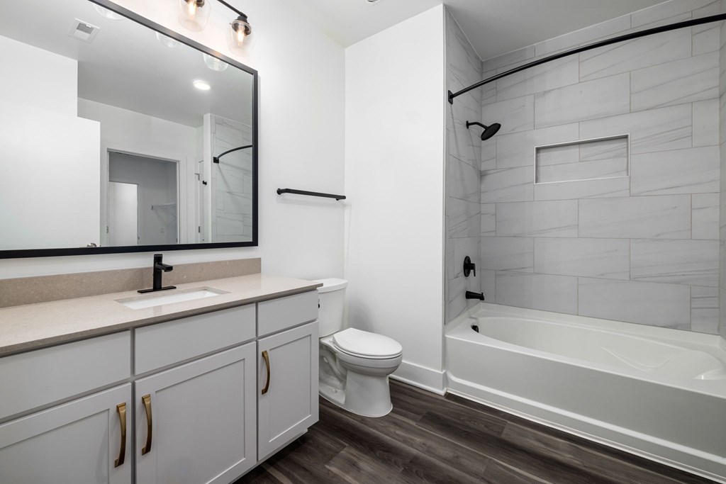 A white bathroom with a tub, toilet, and sink.