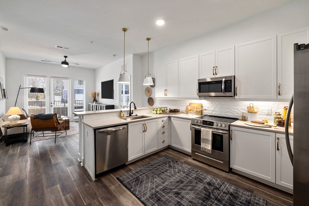 A modern kitchen with white cabinets and stainless steel appliances.