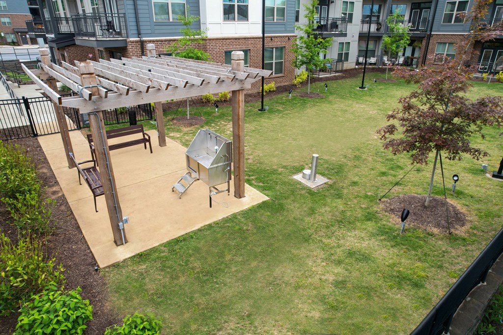 a patio with a grill and a picnic table in a backyard