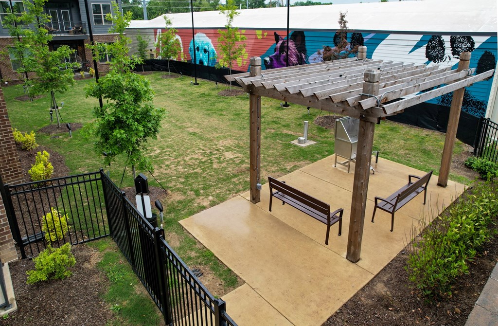 a gazebo with benches and a playground in a yard