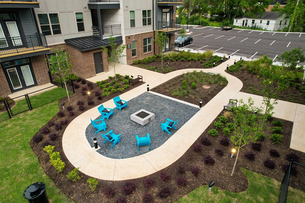 an outdoor patio with blue chairs and tables in an apartment complex