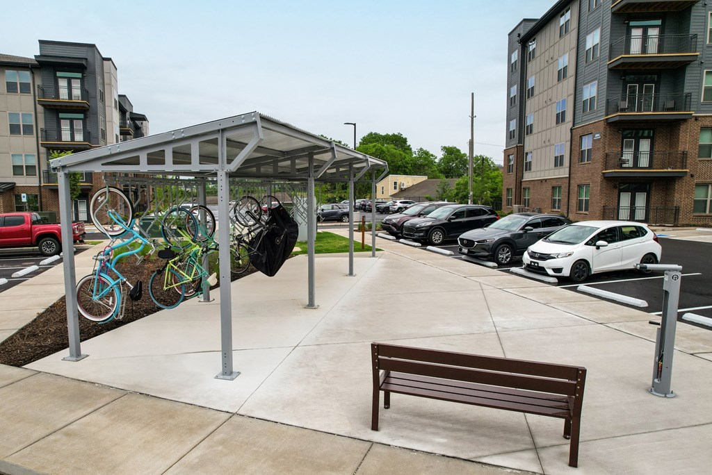 a bench sitting under a shelter on a sidewalk