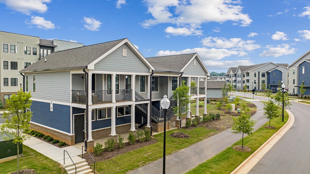 A row of houses with a blue sky and clouds in the background.