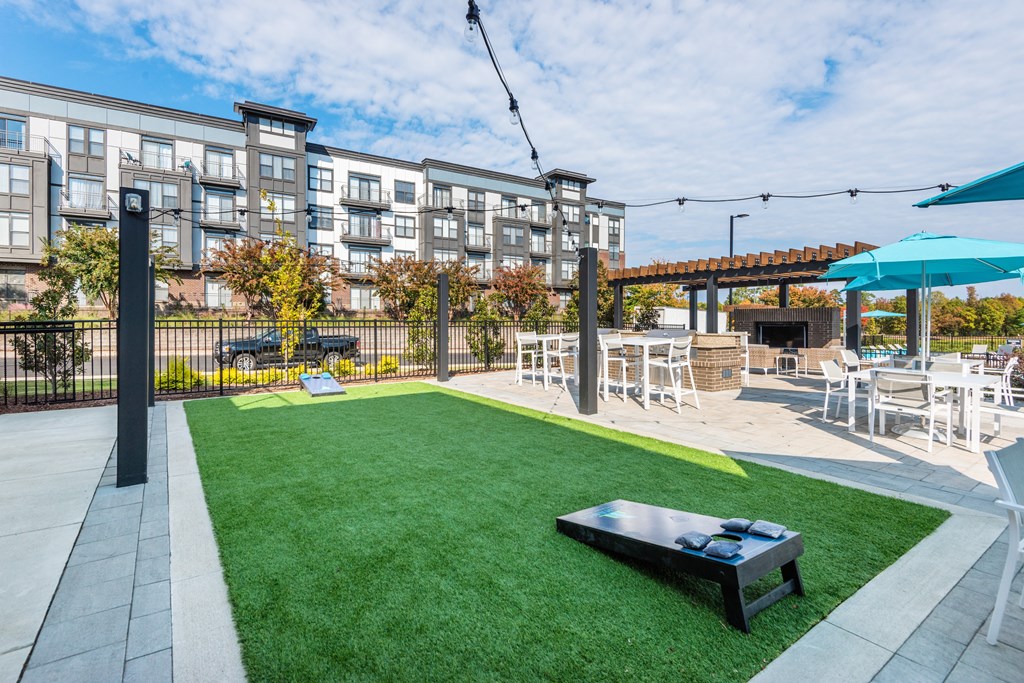 a yard with grass and tables and chairs and a fire pit