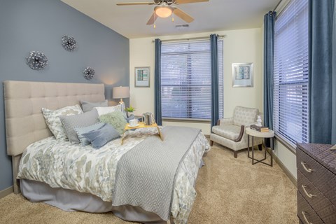 a bedroom with a large bed and two windows