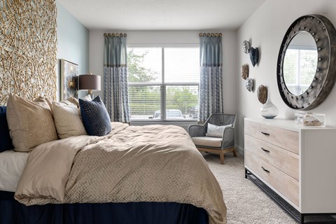 A bedroom with a large bed and a mirror on the wall.