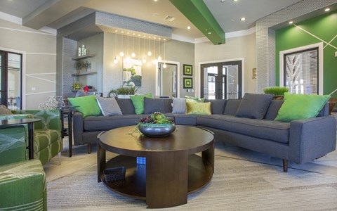 A modern living room with a dark wood coffee table and grey couches.