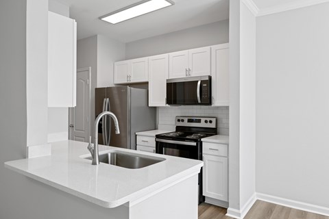 A kitchen with white cabinets and appliances.