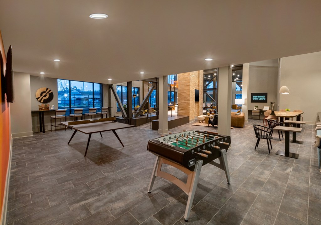 a recreation room with a foosball table and tables