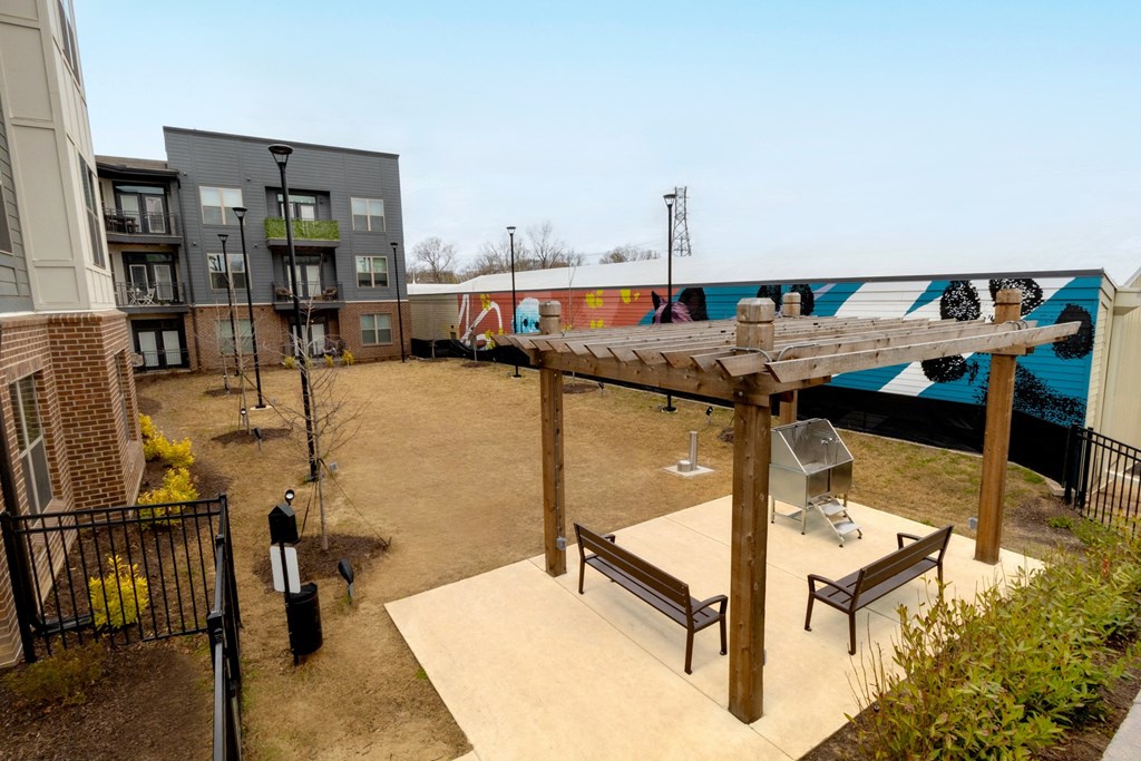 a courtyard with benches and awning in front of apartment buildings