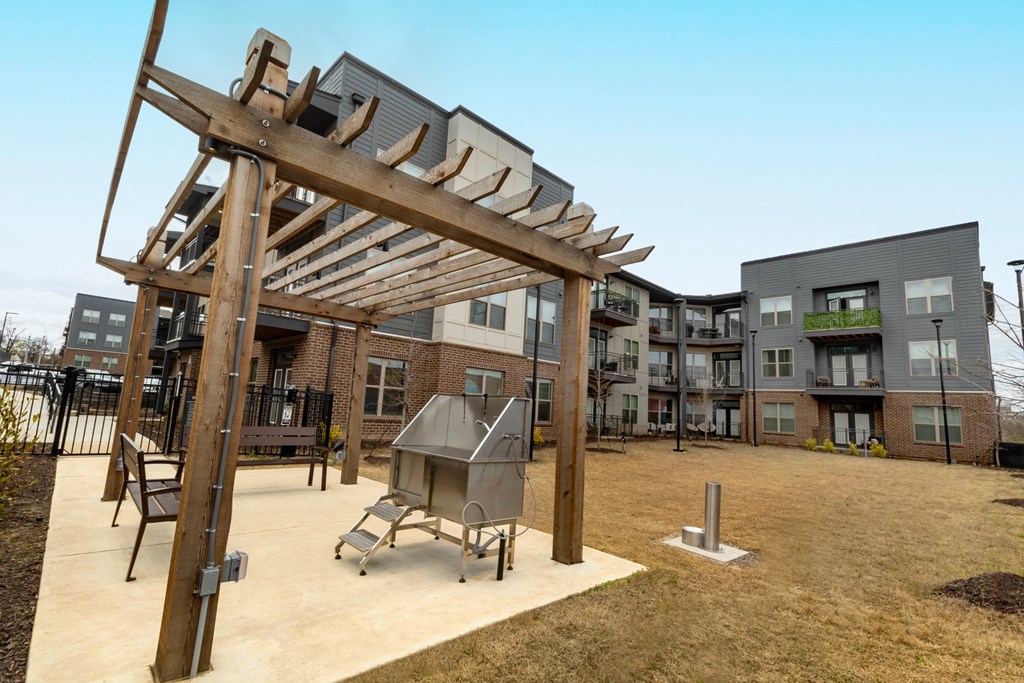 a patio with a barbecue grill in front of an apartment building