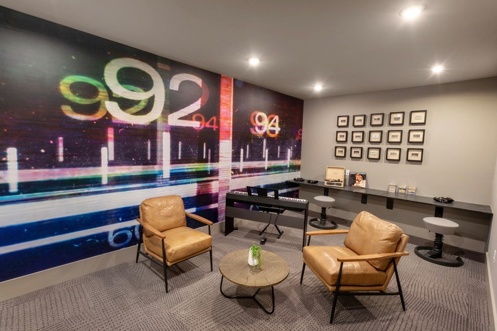 a lounge area with chairs and a piano and graffiti on the wall