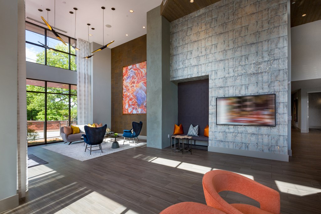 a living room with a stone fireplace and orange furniture