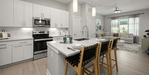 A modern kitchen with white cabinets and a large island.