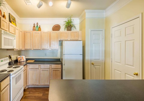 a kitchen with white appliances and wooden cabinets