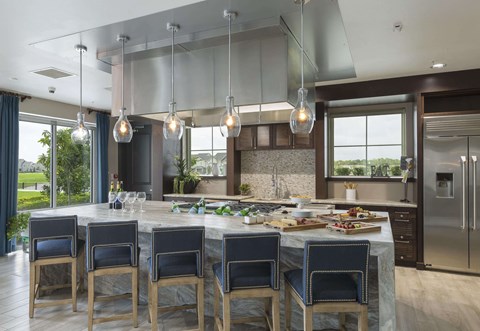 a large kitchen with an island and blue chairs