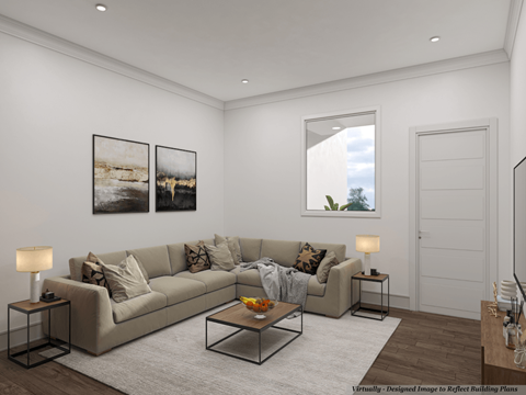 A modern living room with a large couch, a coffee table, and two framed pictures on the wall.