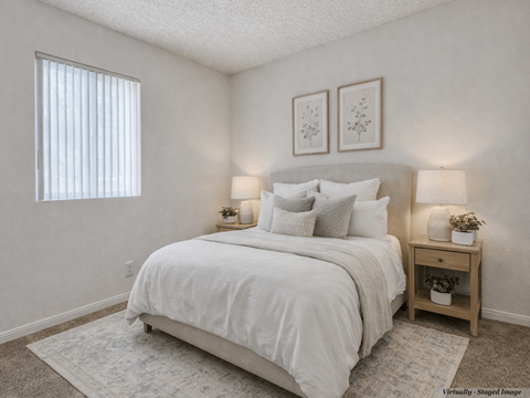 A bedroom with a large bed and two nightstands.