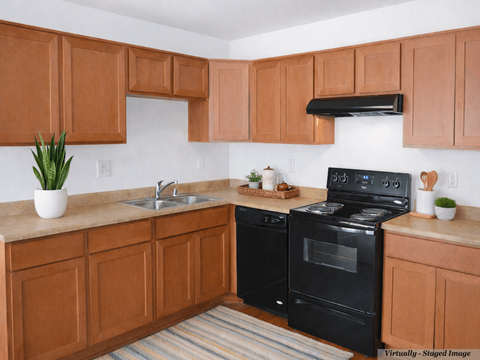 A kitchen with brown cabinets and a black stove top oven.