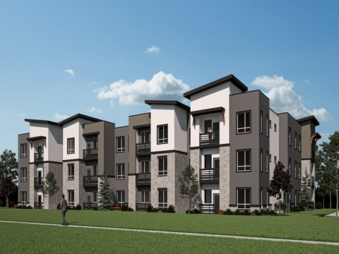 A man is walking in front of a large apartment building.