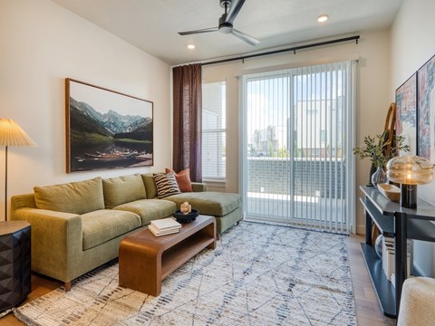 A living room with a couch, a coffee table, and a painting on the wall.