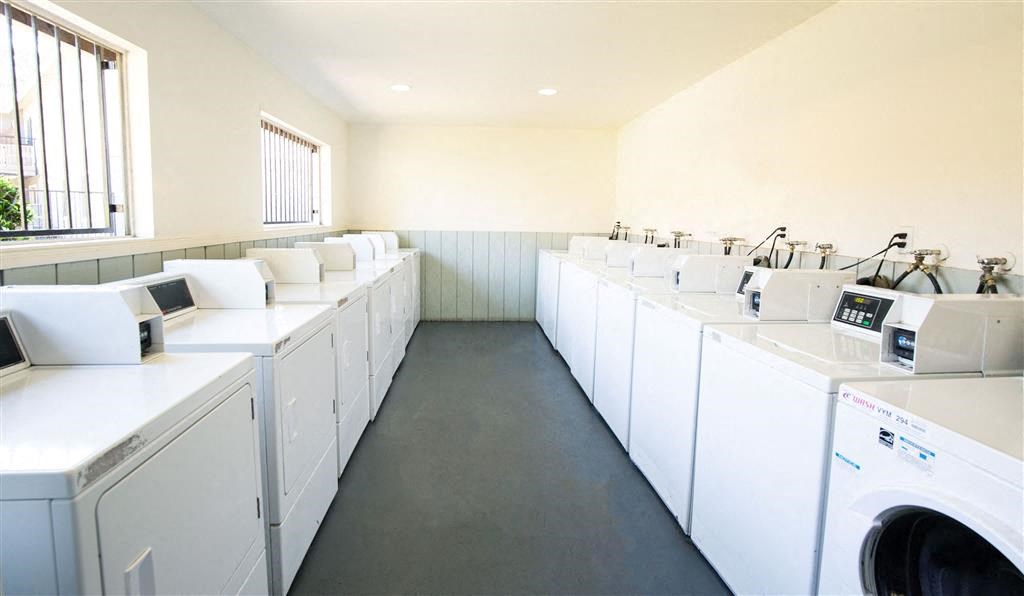 Laundry Center with Machines Next to Folding Counter at Courtyard at Central Park Apartments, California