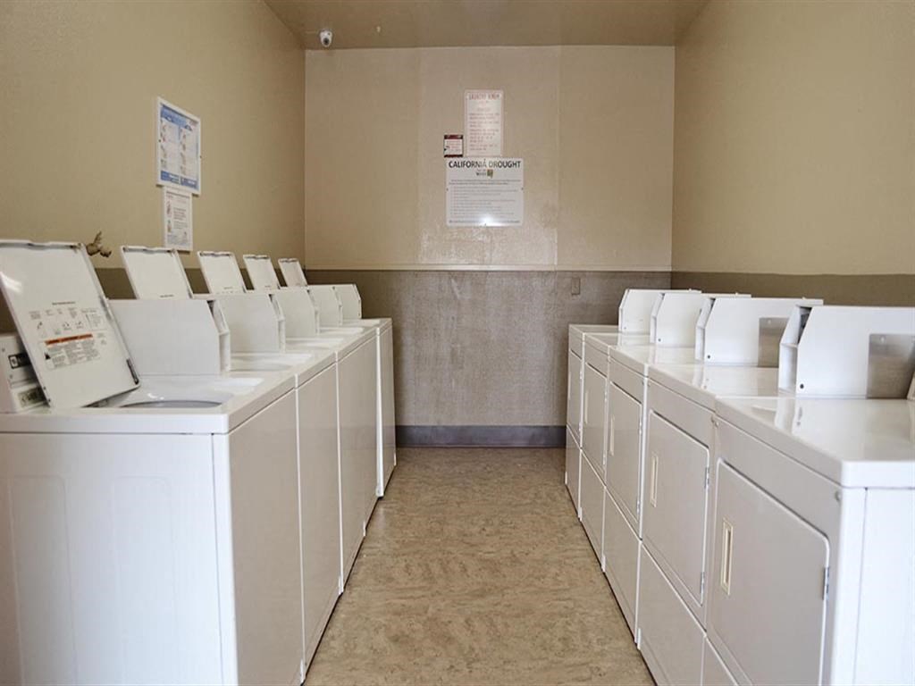 Laundry Center with Machines Next to Folding Counter at California Place Apartments, Sacramento